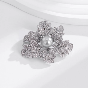 Détails de la broche fleur argentée avec strass scintillants et une perle grise élégante