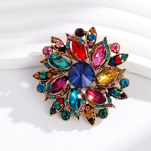Macro detail of vintage floral brooch featuring colorful rhinestones on antique gold base