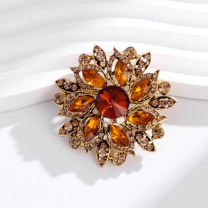 Detail of vintage floral brooch with amber rhinestones and a large red center stone