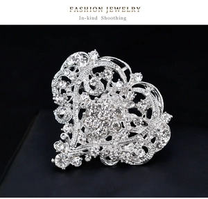 Detail of vintage silver heart brooch with shimmering white rhinestones on black leather