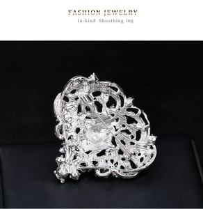 Silver hollow out metal brooch back view with secure safety pin and intricate texture