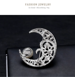 Detailed back view of moon shaped brooch showing the safety pin and hollow texture