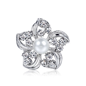 Close-up of elegant flower brooch with white pearl center and sparkling crystal petals