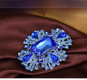Gros plan d'une broche en cristal bleu royal avec pierre précieuse sur soie brune