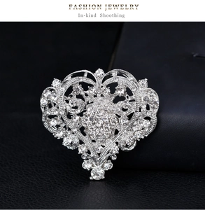 Macro view showing detailed heart-shaped silver brooch with sparkling white rhinestones