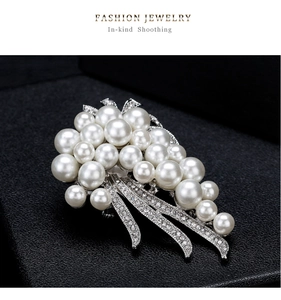 Close-up of elegant 18k pearl flower bouquet brooch with white crystals and silver base