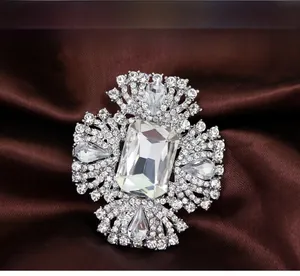 Gros plan d'une grande broche en cristal bleu royal sur un fond en tissu de satin brun
