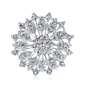 Luxurious silver snowflake brooch with sparkling crystal rhinestones on a white background