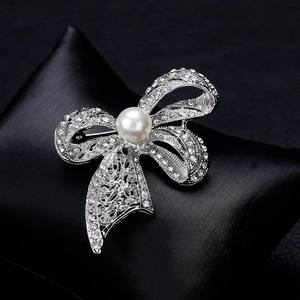 Sparkling crystal bow brooch with a white pearl center on a premium silver metal base