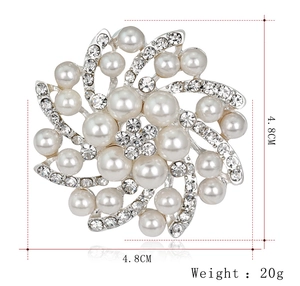 Détail d'une élégante broche fleur en argent avec perles blanches et cristaux brillants