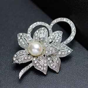 Elegant flower brooch with white pearl and sparkling rhinestones on silver metal base