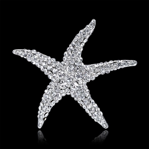 Spilla a forma di stella marina con strass scintillanti su sfondo nero con riflesso