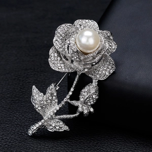 Elegante spilla a rosa argentata con strass scintillanti e grande perla bianca centrale
