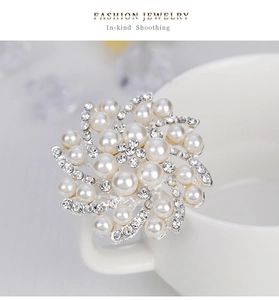 Gros plan d'une broche florale élégante avec perles blanches et zircons sur base argent