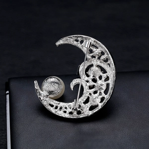 Back view of silver crescent moon brooch with white pearl and filigree hollow design