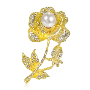 Elegante spilla a rosa con perle bianche e cristalli scintillanti su base dorata