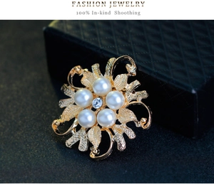 Detailed macro shot of vintage gold floral brooch with pearls and central crystal
