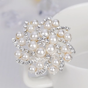 Élégante broche tourbillon argentée avec perles blanches et cristaux étincelants sur tasse