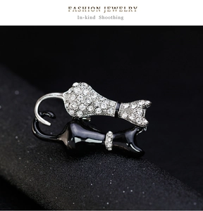 Nahaufnahme der schwarzen Emaille- und glitzernden Strass-Zwillingskatzenbrosche mit Glanz