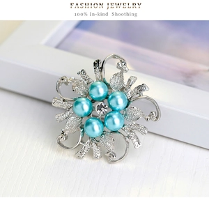 Detail of floral brooch featuring five sky blue pearls and a central crystal diamond