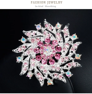 Détail macro d'une broche florale avec cristaux roses et strass AB sur fond noir