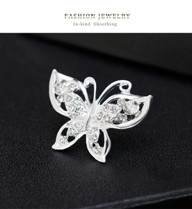 Detailed close-up of a silver butterfly brooch featuring intricate crystal pavé wings