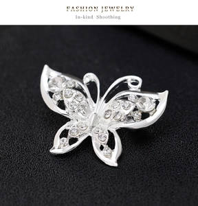Detailed close-up of a silver butterfly brooch featuring crystal rhinestones and hollow wings