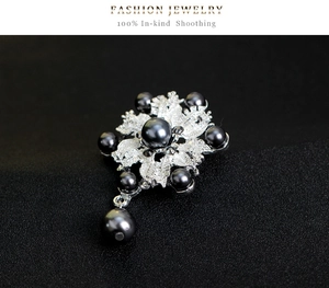 Detalle de broche de flor vintage con perlas grises e intrincados detalles de filigrana plata