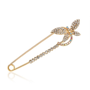 Macro view of golden safety pin brooch featuring butterfly wings with pavé rhinestones