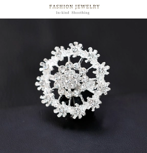 Macro shot of silver snowflake brooch with sparkling zircons on black leather