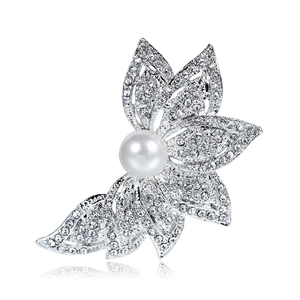 Elegante spilla a fiore argento con grande perla e cristalli su uno sfondo bianco