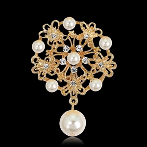 Primer plano de broche de flor dorada con perlas colgantes y cristales brillantes