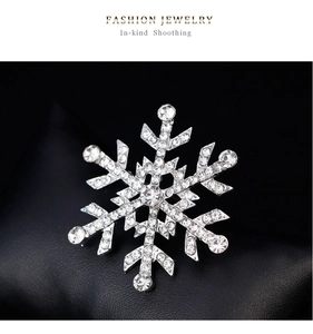 Gros plan d'une broche flocon de neige argentée avec strass scintillants sur cuir noir