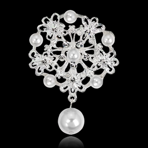 Detalle de broche de flor plateada con diamantes de imitación blancos y perla colgante