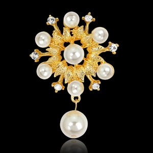 Detalle de un broche de flor con perlas, baño de oro y diamantes de imitación brillantes