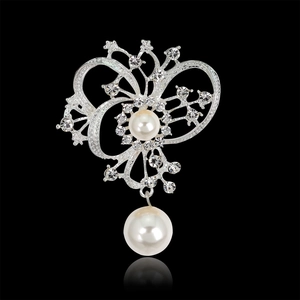 Detalle de broche de aleación plateada con cristales brillantes y colgante de perla