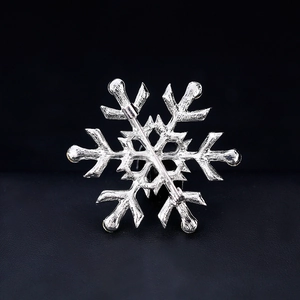 Broche flocon de neige argentée avec texture martelée et fermoir sur fond noir