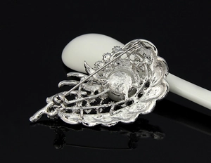 Detail view of silver alloy brooch back with pin clasp and large pearl inlay