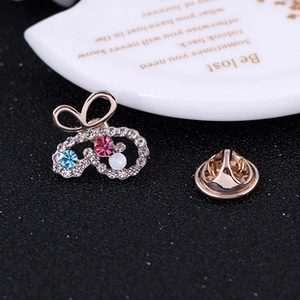 Detailed macro view of the bow-shaped brooch with colorful crystals and golden base