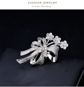 Détail d'une broche nœud argentée avec strass scintillants sur fond en cuir noir