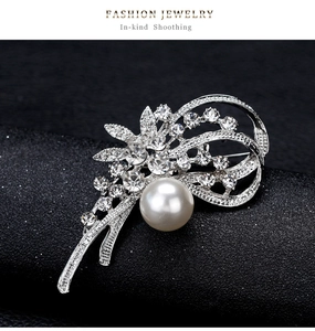 Gros plan de l'élégante broche narcisse avec une grande perle blanche et des strass