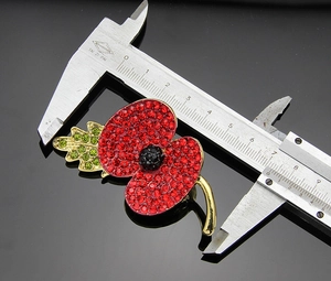 Detailed measurement of the red poppy brooch showing 4.5cm width with a caliper