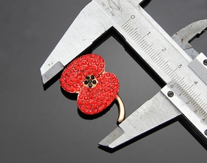 Macro shot measuring the 35mm width of the red rhinestone poppy flower brooch