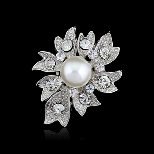Elegant silver flower brooch with a central pearl and sparkling rhinestones on black background