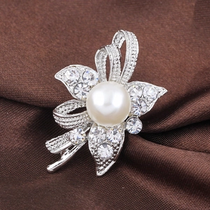Elegant floral brooch with a large white pearl and sparkling rhinestones on satin