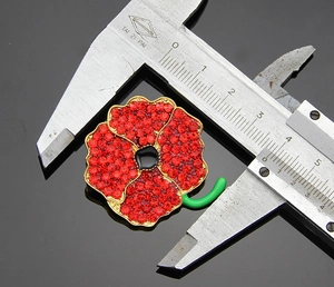 Detailed size measurement of the red poppy flower brooch with a digital caliper