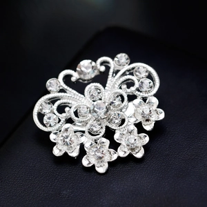 Sparkling silver butterfly brooch with rhinestones on black leather background