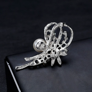 Broche fleur de narcisse argentée avec perle montrant le dos évidé et le fermoir à épingle