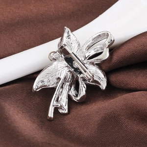 Back view of silver floral pearl brooch pin with secure metal clasp on brown satin silk