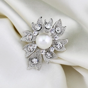 Broche fleur en perle argentée élégante avec cristaux brillants sur soie blanche